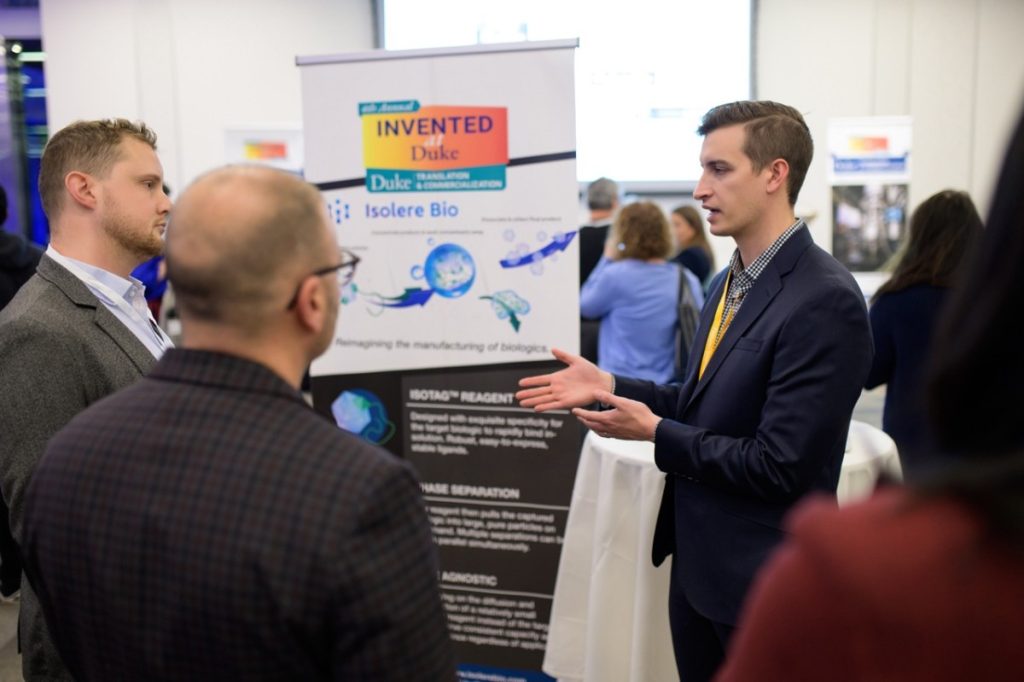 Michael Dzuricky, right, describes the Isolere booth to attendees.